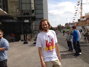 Andreas Bennetzen standing on Næstved harbor with the Royal ship in the background wiating to perform for Hendes Majestæt Dronning Margrethe den anden af Danmark. A fine example of Andreas Bennetzen collaborating with other artists such as dancers and musicians